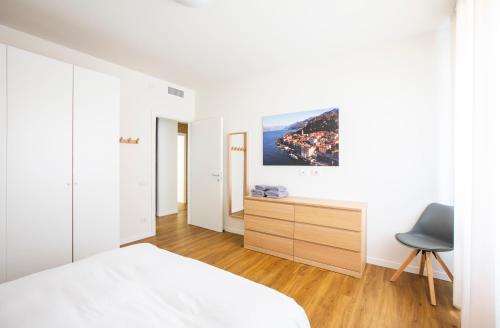 a bedroom with a bed and a desk and a chair at Appartamenti 2 in Dervio