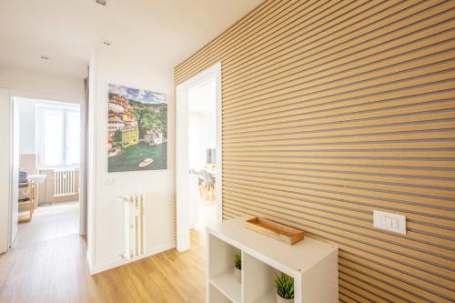 a room with a striped wall with a white table at Appartamenti 2 in Dervio