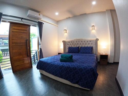 a bedroom with a bed with a blue comforter at Krabi Top Sea Hill Villa in Klong Muang Beach