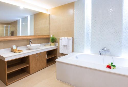 a bathroom with a tub and a sink at The Cliff Resort & Residences in Mui Ne