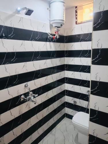 a bathroom with black and white striped walls and a toilet at Hotel Tara ji Bliss in Haridwār