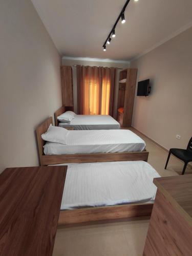 a room with two beds and a table and a chair at Hotel Lalez Durres in Durrës