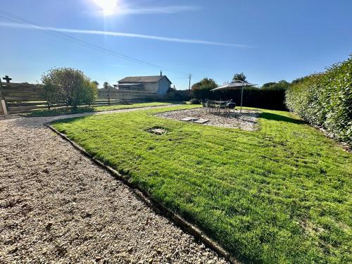 a field of grass with a house in the background at Renovated French Country House for Six - A Home for Your Next Holiday in Hercé