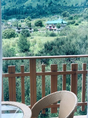 a table and chairs on a balcony with a view at Mystic Manali in Palchān