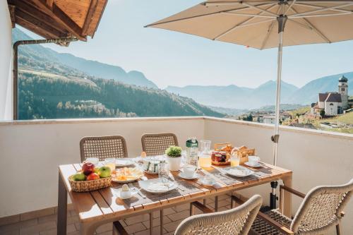 a table with a bowl of fruit and an umbrella at Oberegghof Ferienwohnung Ifinger in Rifiano
