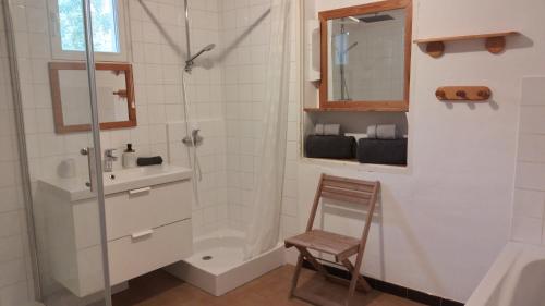 bagno con doccia, lavandino e sedia di Familien Resort Haus a Armissan