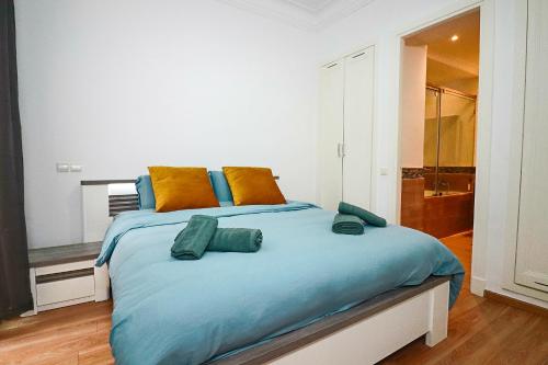 a bedroom with a large bed with orange and blue pillows at Lagoon Garden - 2 chambres proche Plage avec Piscine in Skhirat