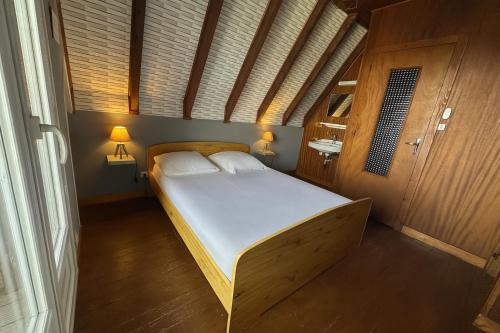 a bedroom with a bed in a room with two lamps at Le Delta de Super-Besse in Super Besse