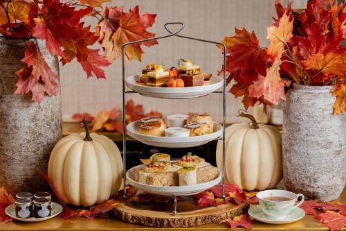 a three tiered display of food on a table with pumpkins at Roslin Beach Hotel in Southend-on-Sea