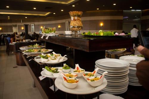 Una línea de buffet con platos y tazones de comida en Hotel Presidential, en Port Harcourt