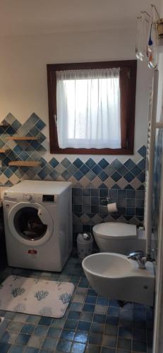 a small bathroom with a toilet and a sink at Casa Villetta Vacanze Budoni in Budoni
