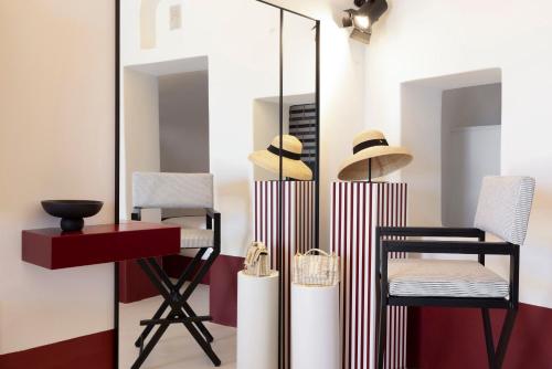 a room with a mirror and a table and chairs at Neema Maison Finikia Santorini in Oia