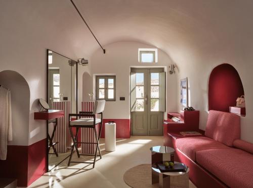 a living room with a red couch and a table at Neema Maison Finikia Santorini in Oia