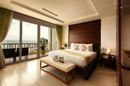 a bedroom with a large bed and a balcony at The Cliff Resort & Residences in Mui Ne