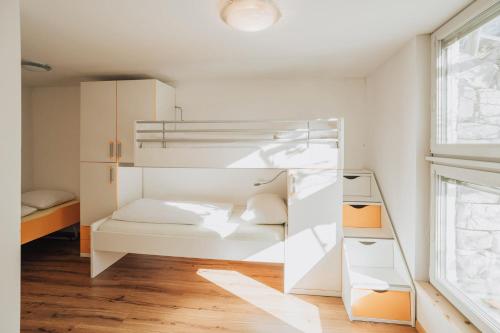 a white bunk bed in a room with a window at Oberegghof Ferienwohnung Garten in Rifiano