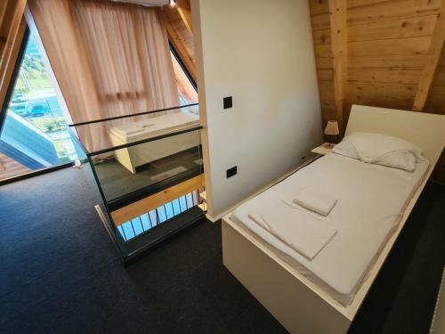a small room with a bed and a window at Bungalov Damiano's 9 in Podbrdo