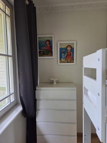 a bedroom with a dresser and two pictures on the wall at Baltic beach villa 2 in Jūrmala
