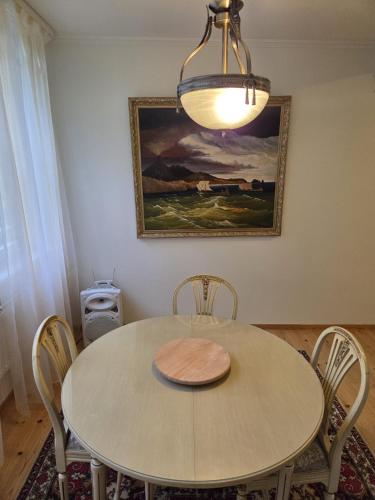 a dining room table with chairs and a chandelier at Baltic beach villa 2 in Jūrmala