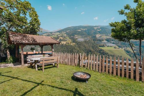 a grill in the grass next to a bench and a table at Oberegghof Ferienwohnung Garten in Rifiano