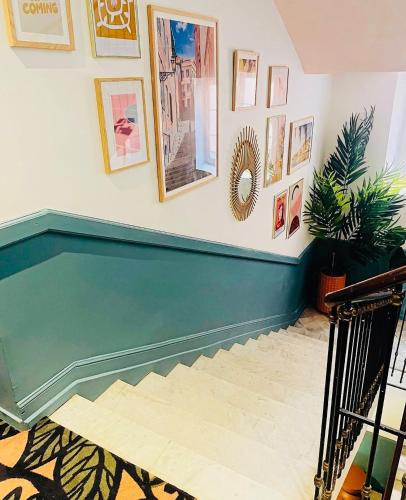 a hallway with a stairway with pictures on the wall at Hôtel De Londres in Menton