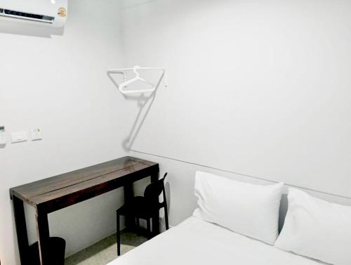 a bedroom with a bed with a desk and a chair at Mitr Inn Khaosan BKK in Bangkok