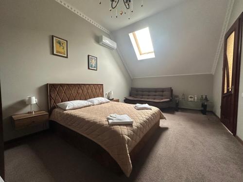 a bedroom with a bed and a chair and a window at U Dominicana in Kamianets-Podilskyi