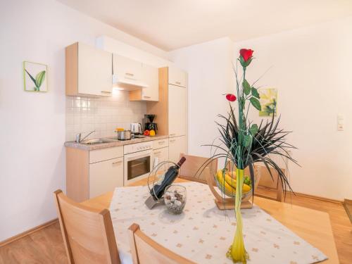 a kitchen with a table with a vase of flowers on it at Apartment in Neustift in a quiet location in Neustift im Stubaital