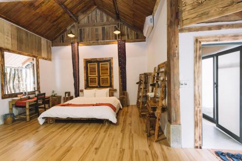 a bedroom with a bed and wooden floors at The Nordic Village - Evergreen Retreat in Mộc Châu