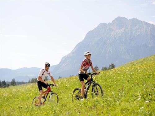 two people riding bikes in a field of flowers at Apartment in Neustift in a quiet location in Neustift im Stubaital