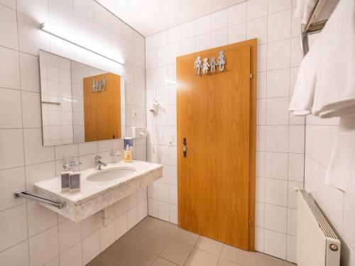 a bathroom with a sink and a wooden door at Apartment in Neustift in a quiet location in Neustift im Stubaital
