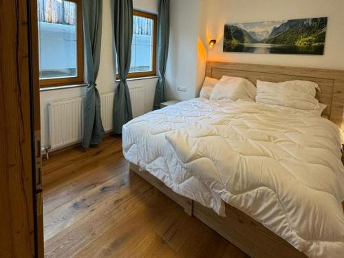 a bedroom with a white bed with two windows at Apartment in Neustift in a quiet location in Neustift im Stubaital