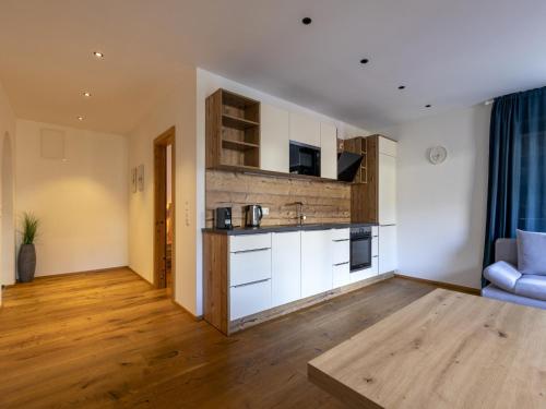 a kitchen with white cabinets and a blue couch in a room at Apartment in Neustift in a quiet location in Neustift im Stubaital