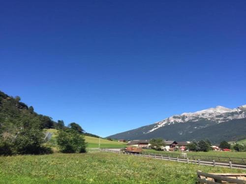 a train in a field with mountains in the background at Apartment in Neustift in a quiet location in Neustift im Stubaital