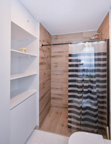 Fernando de la MoraにあるWork & Relax 1BR Plus Amenities Zubaのガラスドア付きのシャワー付きのバスルーム