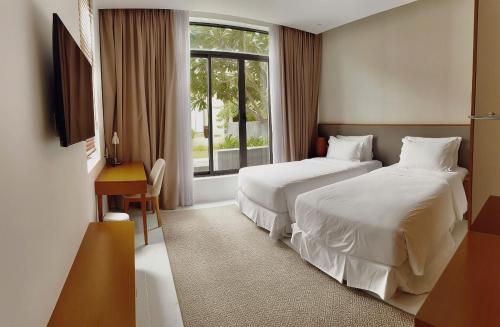 a hotel room with two beds and a window at Alexa Villa Cam Ranh - 3 Bedrooms, Private Pool, Beach Access in Cam Lâm