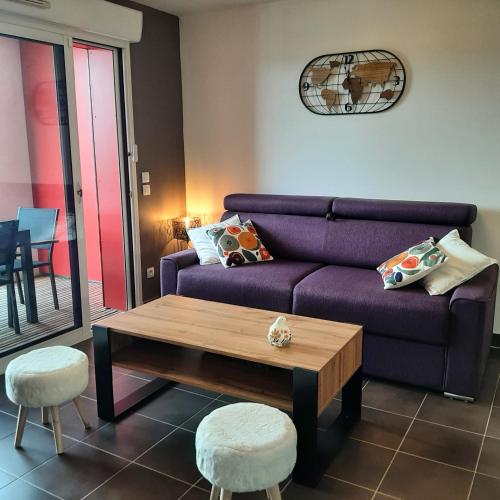 - un salon avec un canapé violet et une table basse dans l'établissement Le Patio Arena, classé 2 étoiles, terrasse, parking, wifi, local vélos, à Bayonne