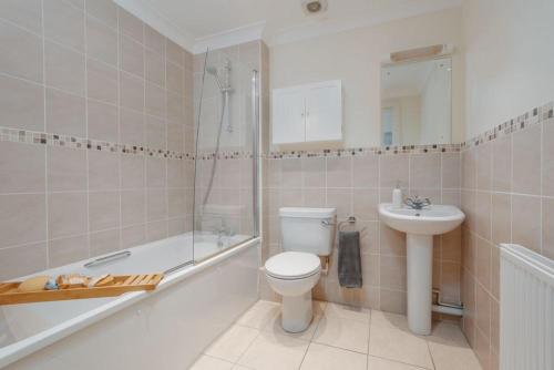 ein Badezimmer mit Toilette, Waschbecken und Badewanne in der Unterkunft Sea Breeze in Ulwell