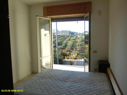 a bedroom with a bed and a large window at La Suite in Torrevecchia Teatina
