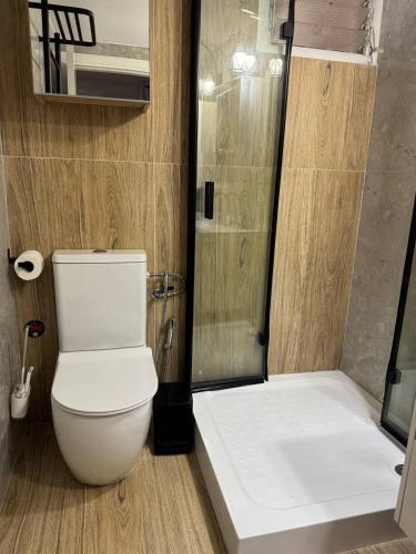 a bathroom with a white toilet and a shower at Cozy apartment in Nahariyya