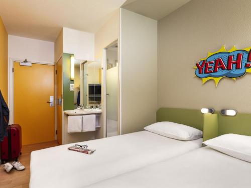 a hotel room with two beds and a bathroom at ibis budget Warszawa Centrum in Warsaw