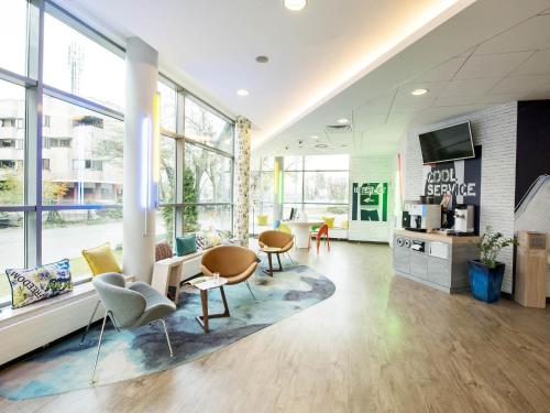 a large room with chairs and tables and windows at ibis budget Warszawa Centrum in Warsaw