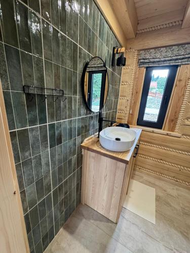 a bathroom with a sink and a mirror at Świerkowe Chatki w Koniakowie in Koniaków