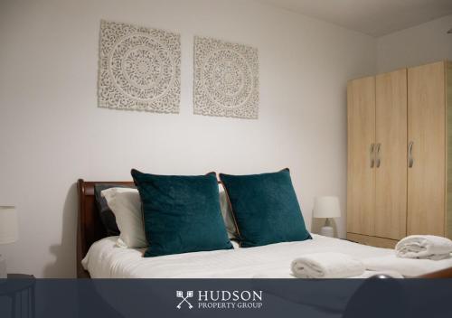a bedroom with a bed with green pillows and a cabinet at Telford Centre - 2 Bed Apartment in Telford