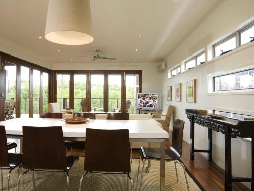 a dining room with a large white table and chairs at The Sebel Twin Waters in Twin Waters