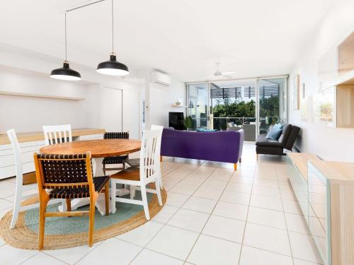 a dining room and living room with a table and chairs at The Sebel Twin Waters in Twin Waters