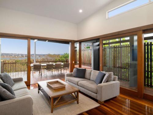 a living room with two couches and a table at The Sebel Twin Waters in Twin Waters