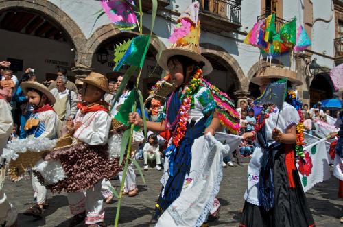 a group of children in costumes playing in a parade at Casa de la Real Aduana Boutique Hotel in Pátzcuaro