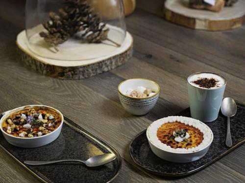 a table with bowls of food and cups of coffee at Mercure Valence in Valence