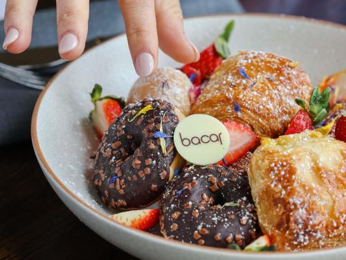 a person reaching for a dessert in a bowl of strawberries at Pullman Sydney Olympic Park in Sydney