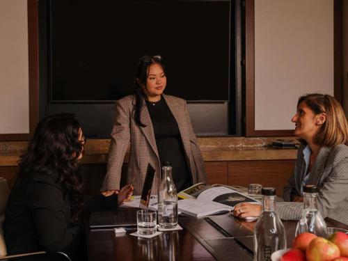 three women sitting around a table in a meeting at Pullman Sydney Olympic Park in Sydney